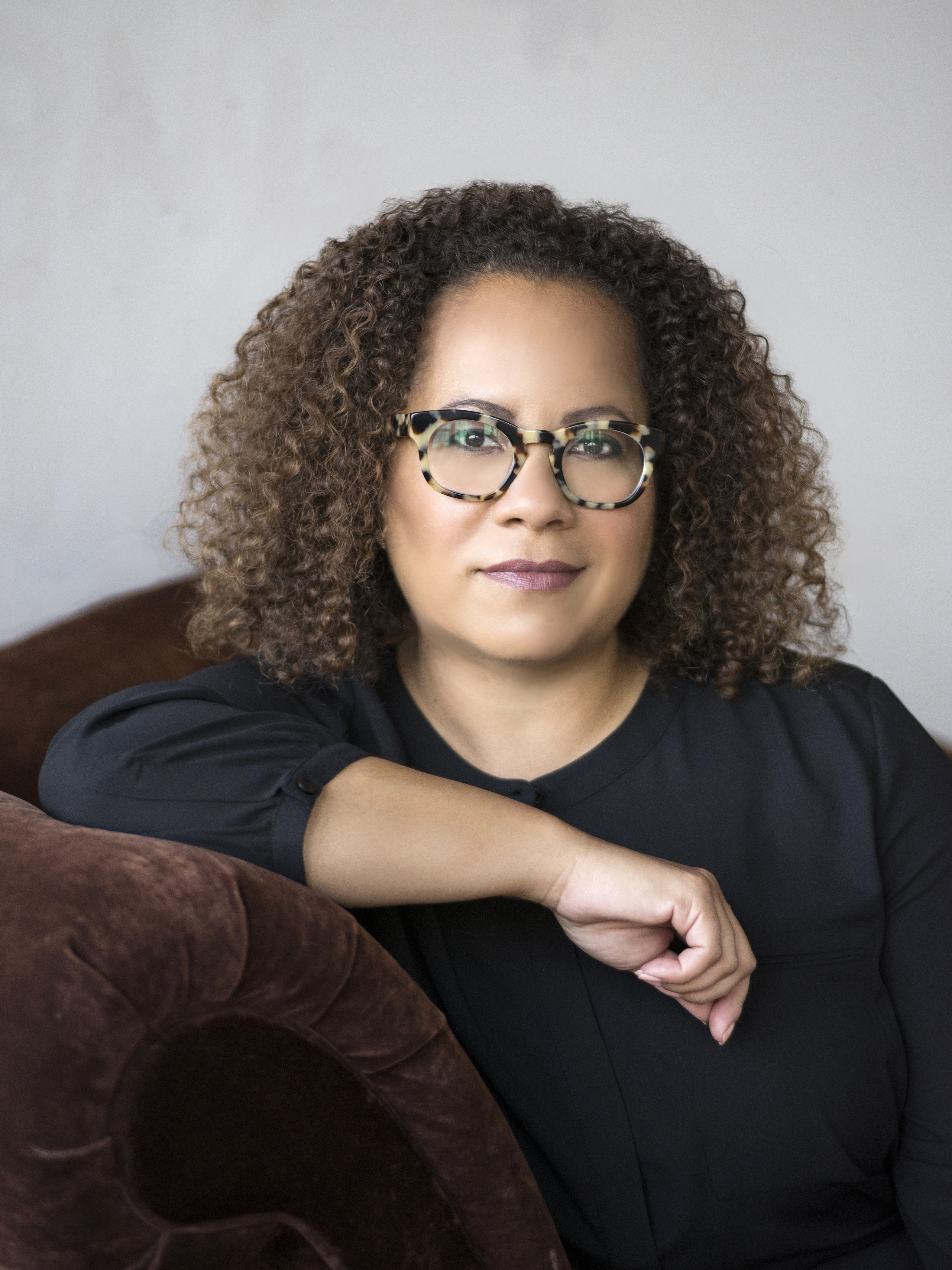Headshot of Erica Armstrong Dunbar posting in arm chair.
