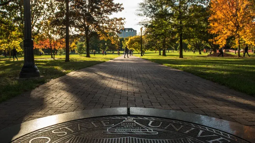 Closeup of a sunlit Ohio State University seal looking over the Oval