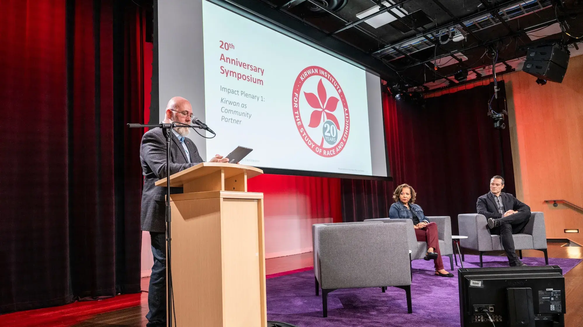 Man speaking on-stage at the Kirwan 20th Anniversary Symposium