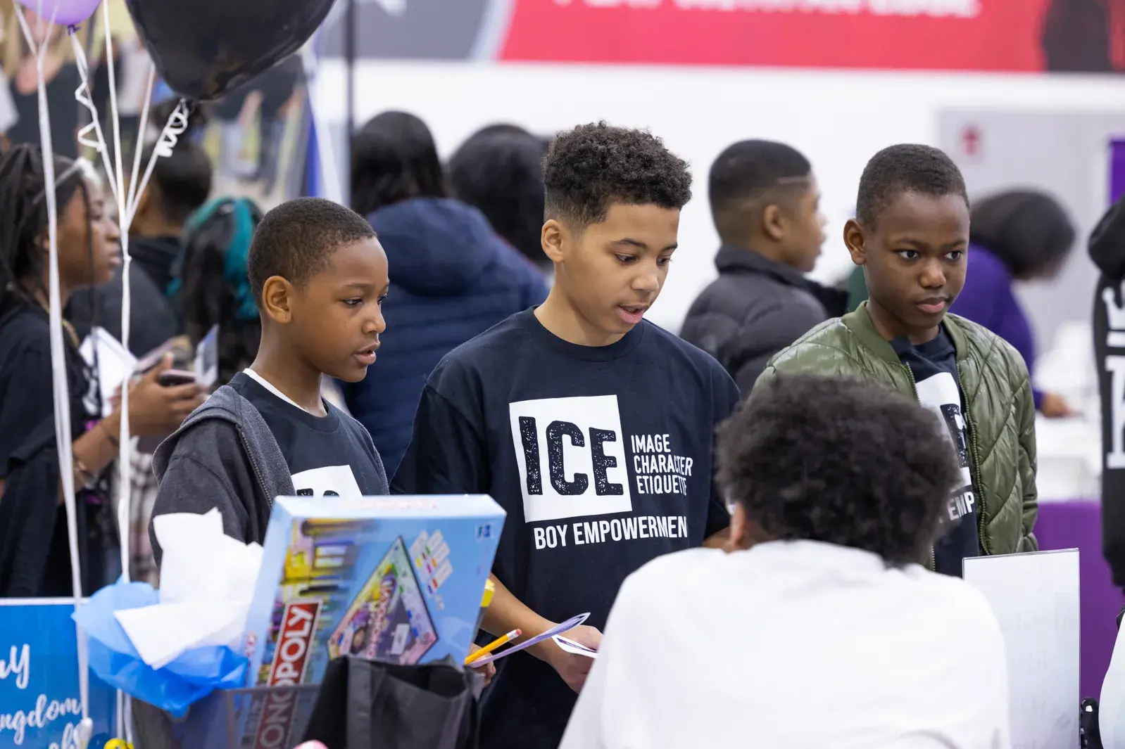 Three students at a table in the ICE college and career fair